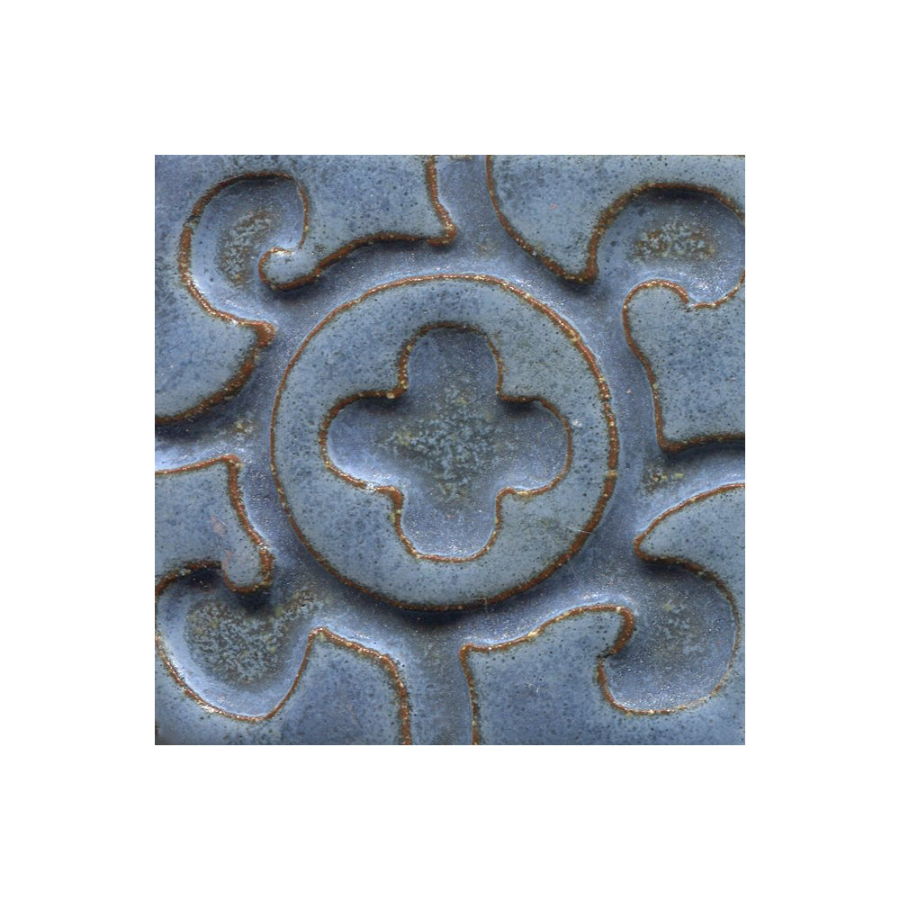 A collection of tiles featuring a stamped clover pattern in matte blue