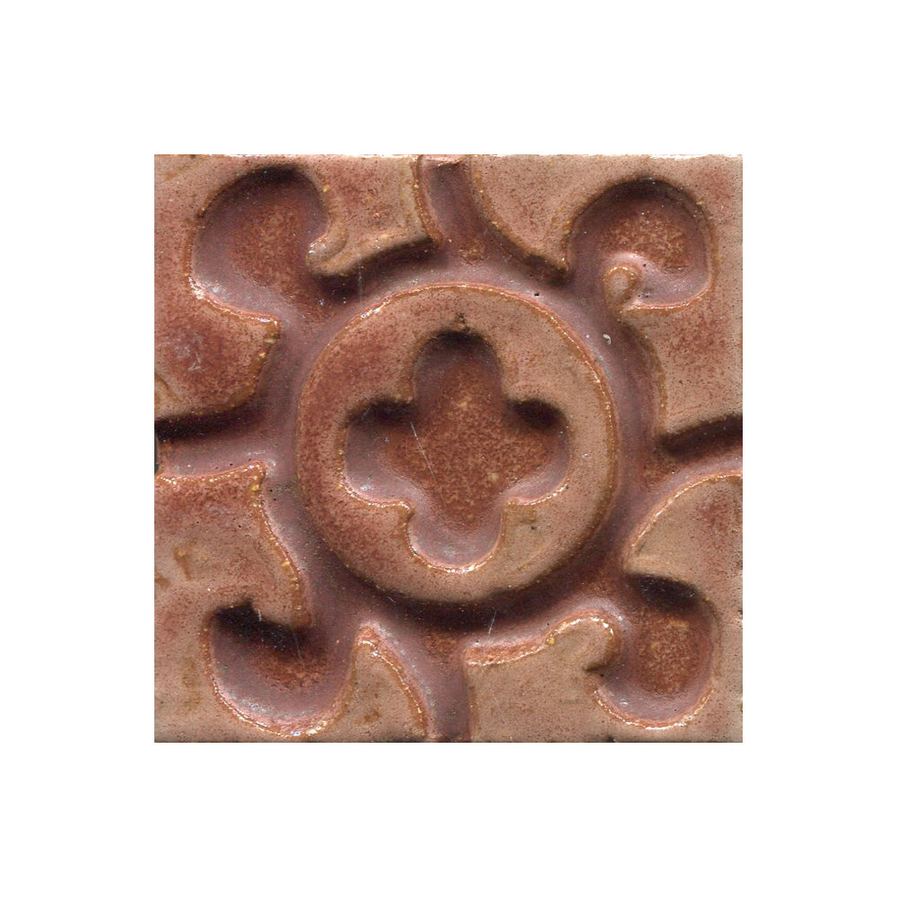 A collection of tiles featuring a stamped clover pattern in Chai matte brown