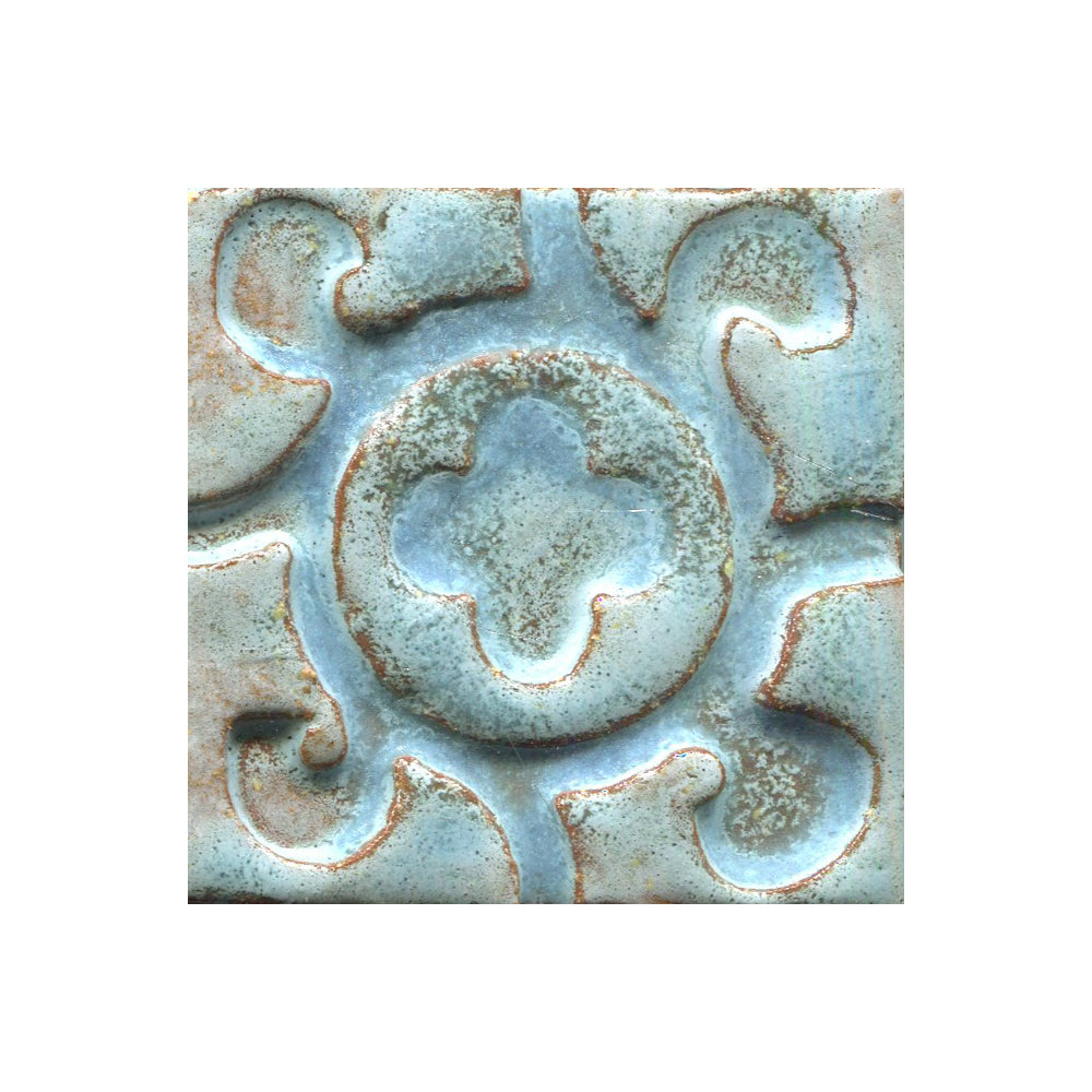 A collection of tiles featuring a stamped clover pattern in mottled blue
