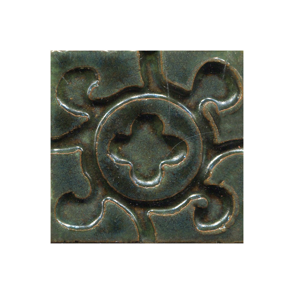 A collection of tiles featuring a stamped clover pattern in Jade Moss green