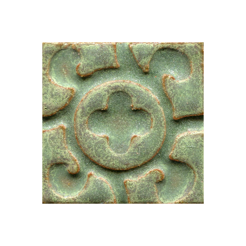 A collection of tiles featuring a stamped clover pattern in rosemary green