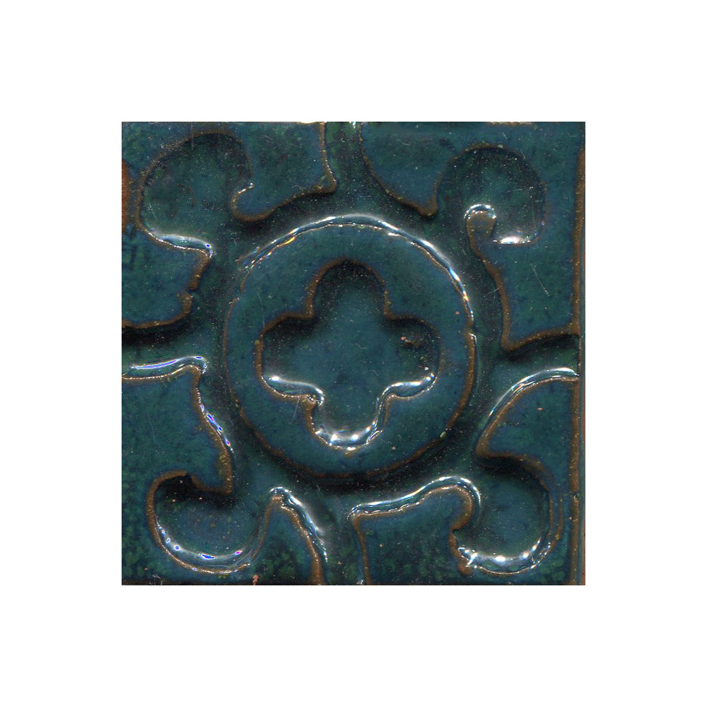 A collection of tiles featuring a stamped clover pattern in teal green