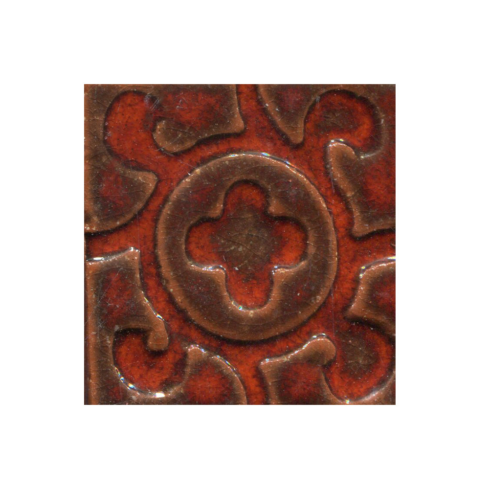 A collection of tiles featuring a stamped clover pattern in Yam orange