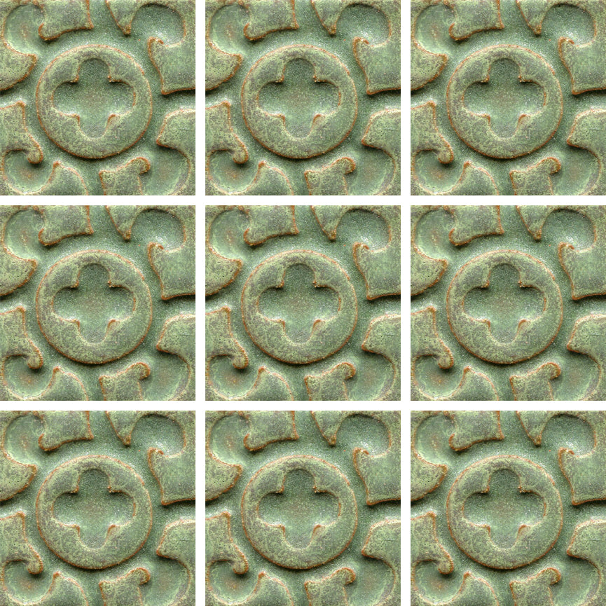 A collection of tiles featuring a stamped clover pattern in avocado green