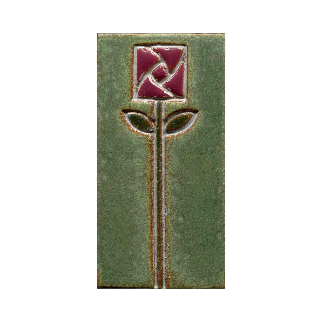 A rectangular ceramic tile with a stamped floral design in the center, featuring blue petals and green leaves.