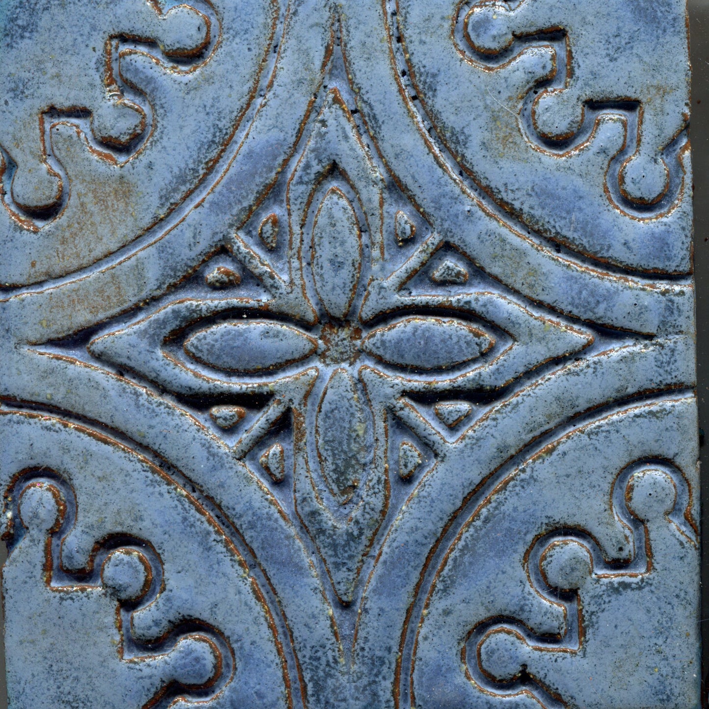 A collection of blue stamped tiles with a floral pattern.
