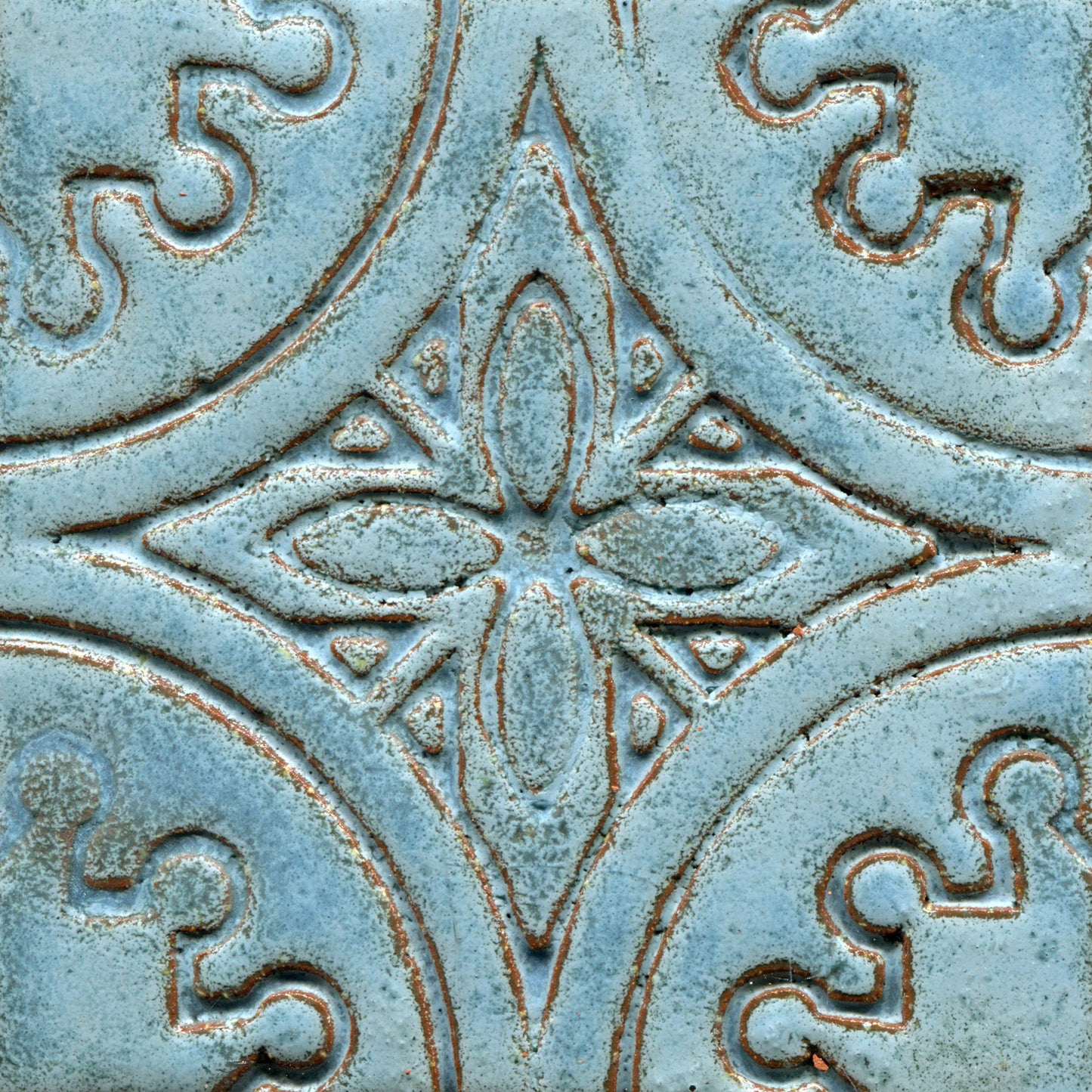 A collection of blue stamped tiles with a floral pattern.