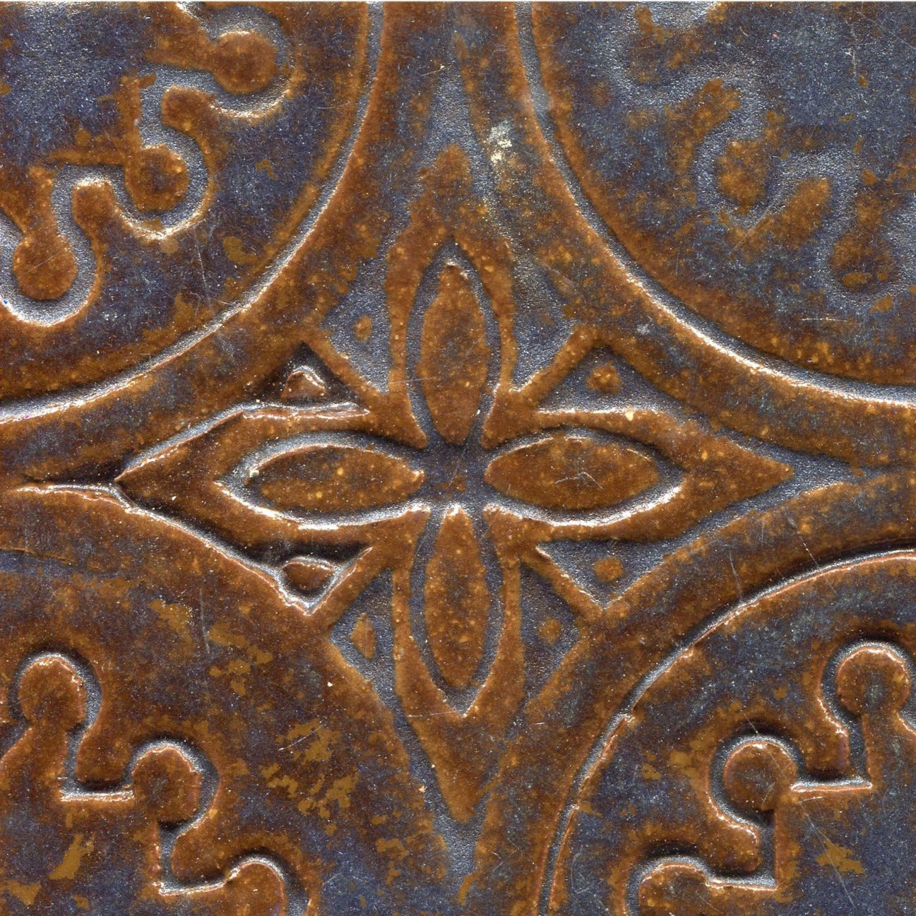 A collection of Copper-blue stamped tiles with a floral pattern.