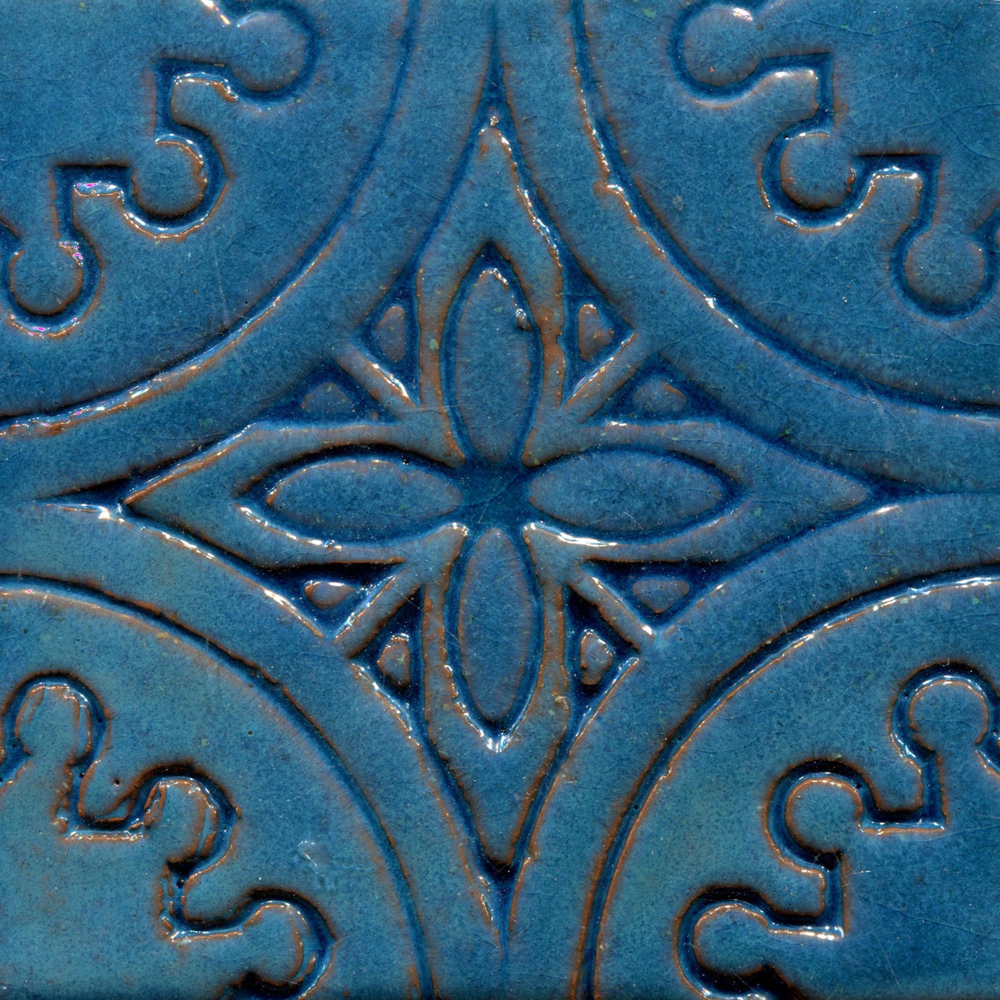 A collection of blue stamped tiles with a floral pattern.