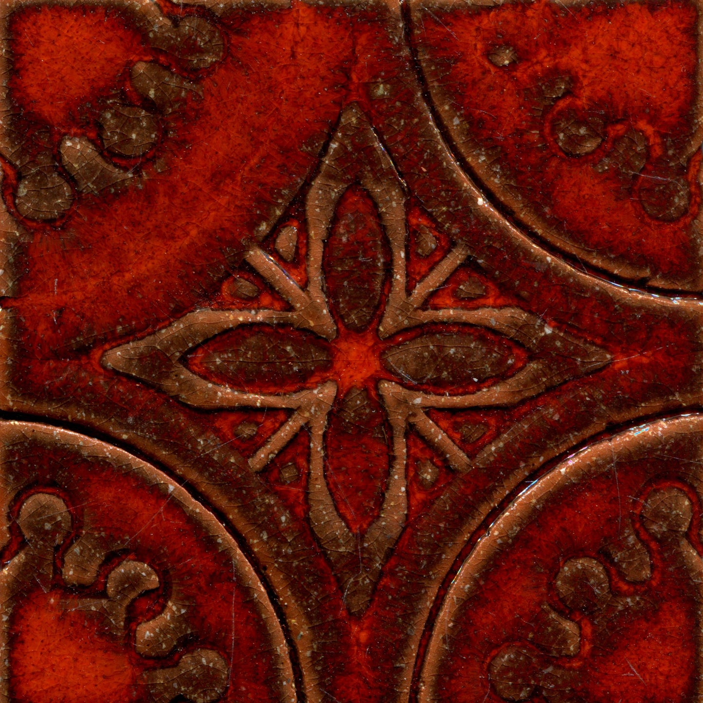 A collection of orange stamped tiles with a floral pattern.