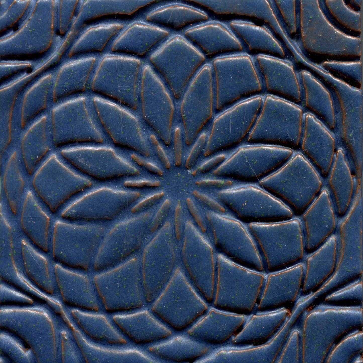 Deep blue stamped tile with a geometric floral pattern.