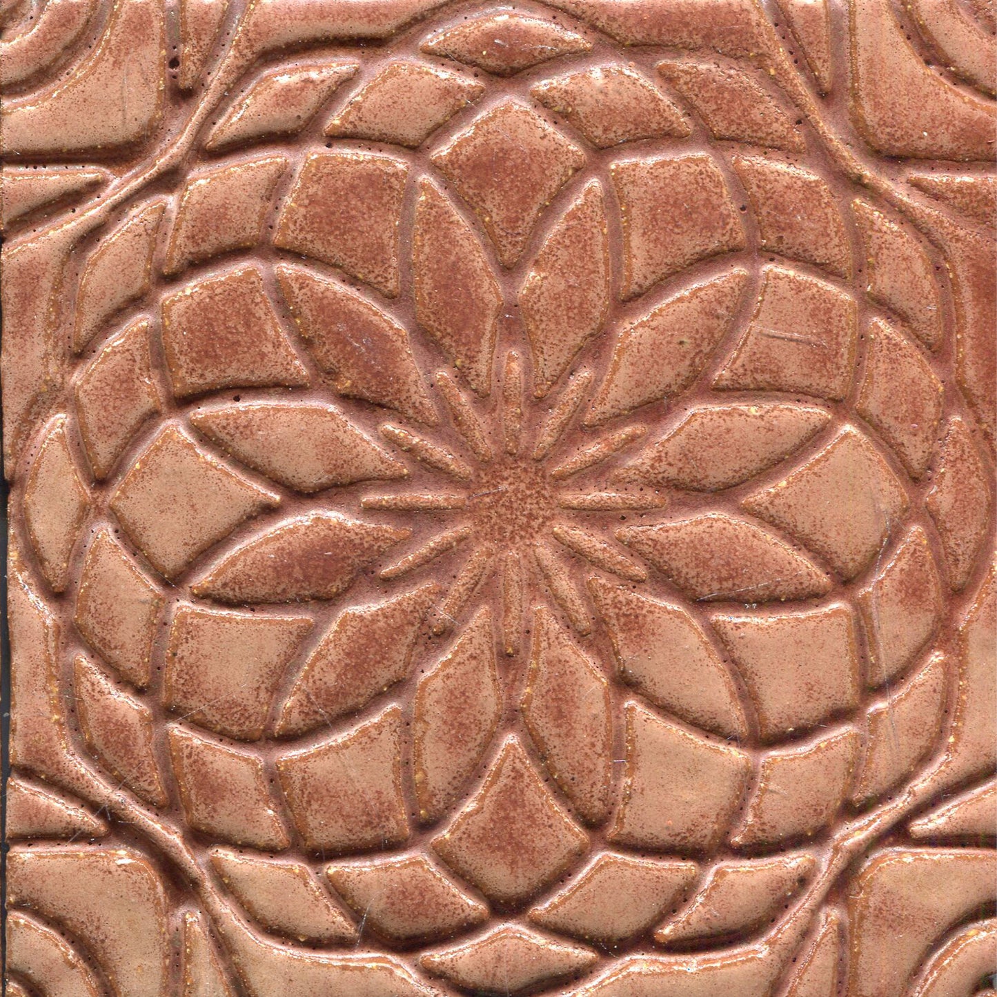 brown stamped tile with a geometric floral pattern.