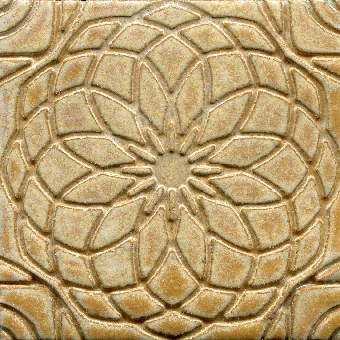 Golden brown stamped tile with a geometric floral pattern.
