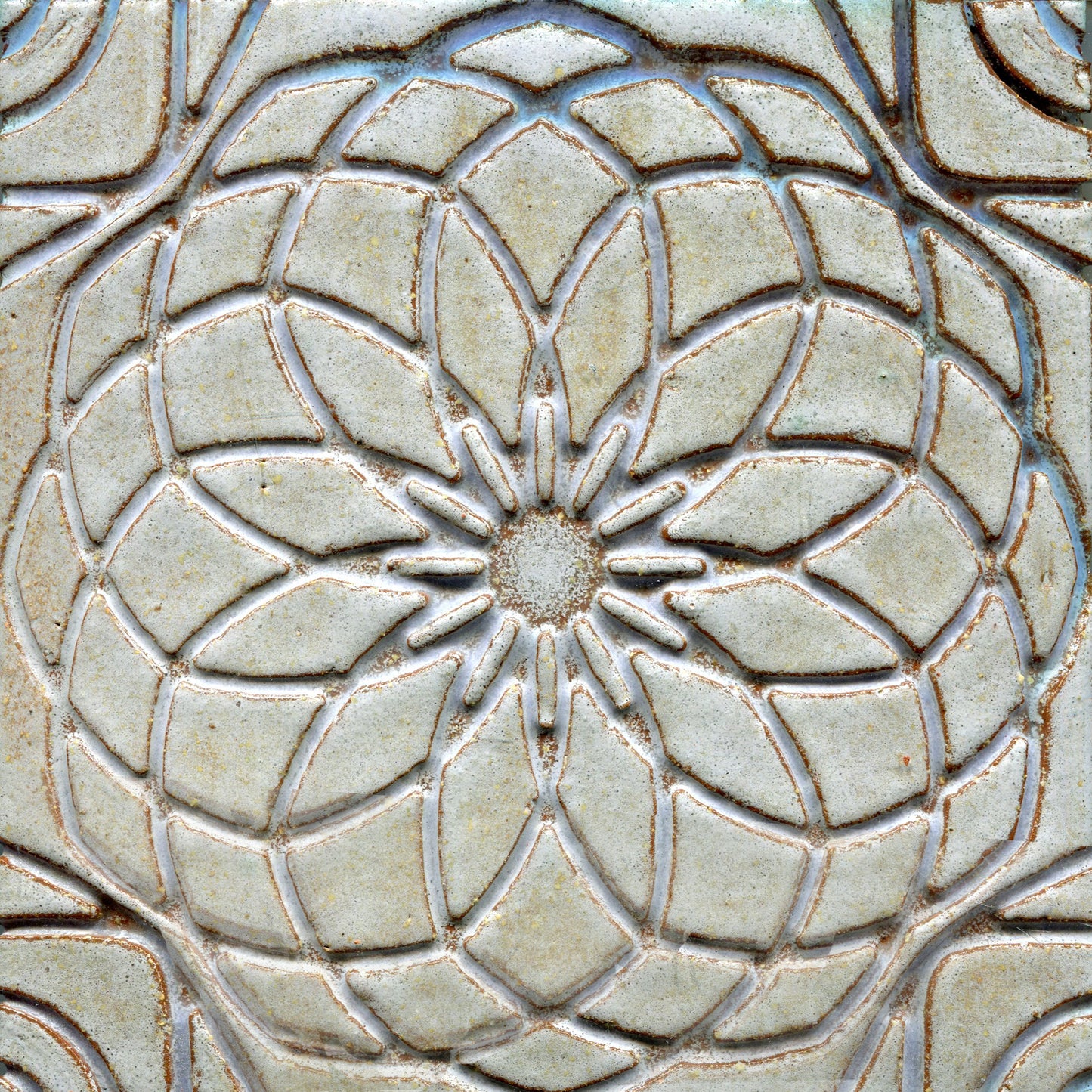 Grey stamped tile with a geometric floral pattern.