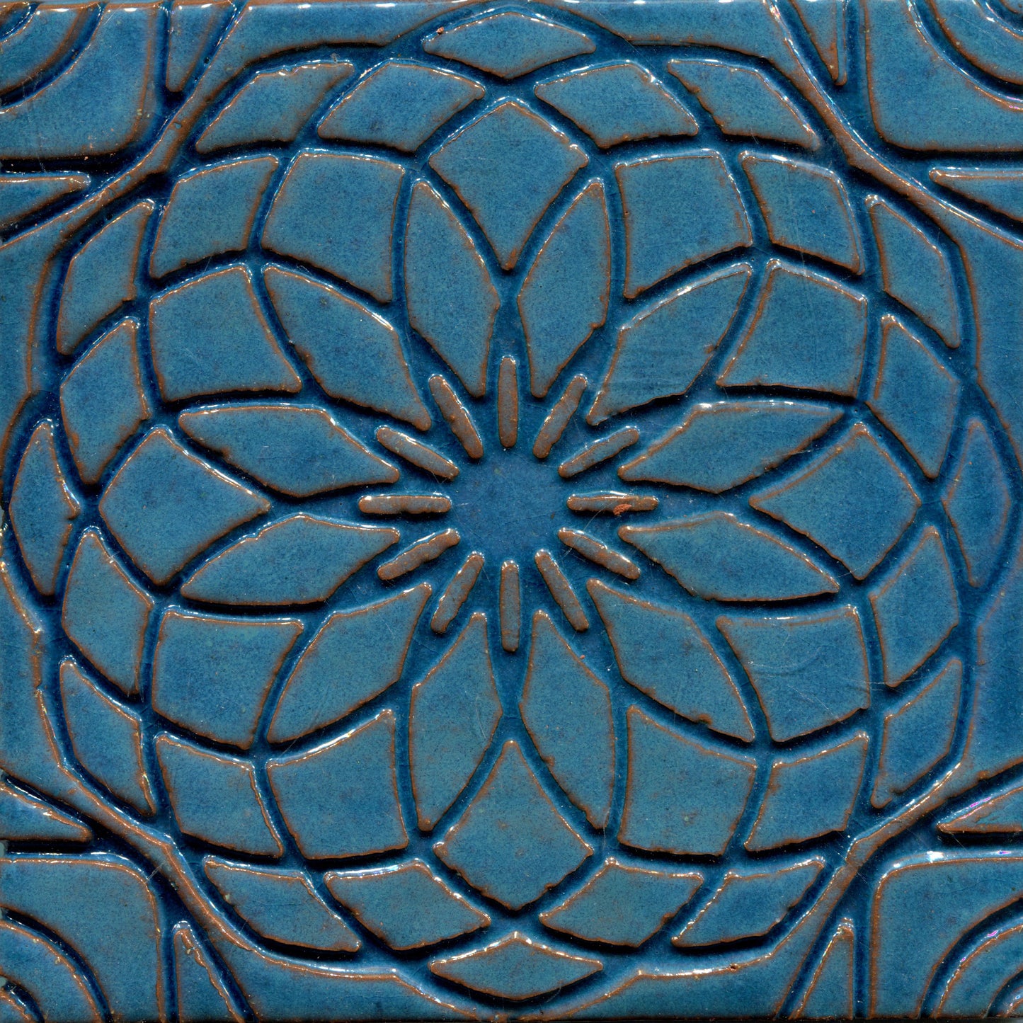 Blue stamped tile with a geometric floral pattern.