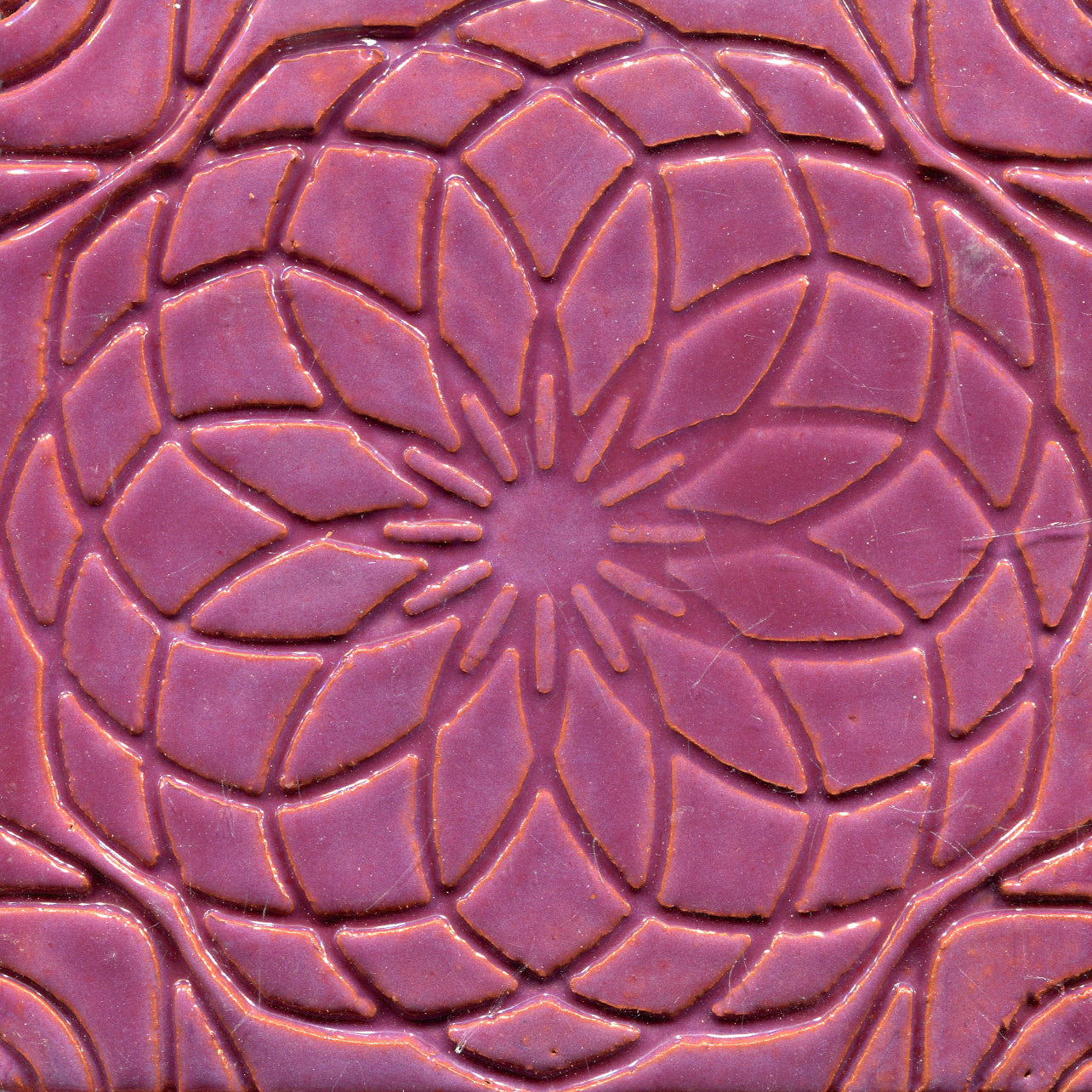 pink stamped tile with a geometric floral pattern.