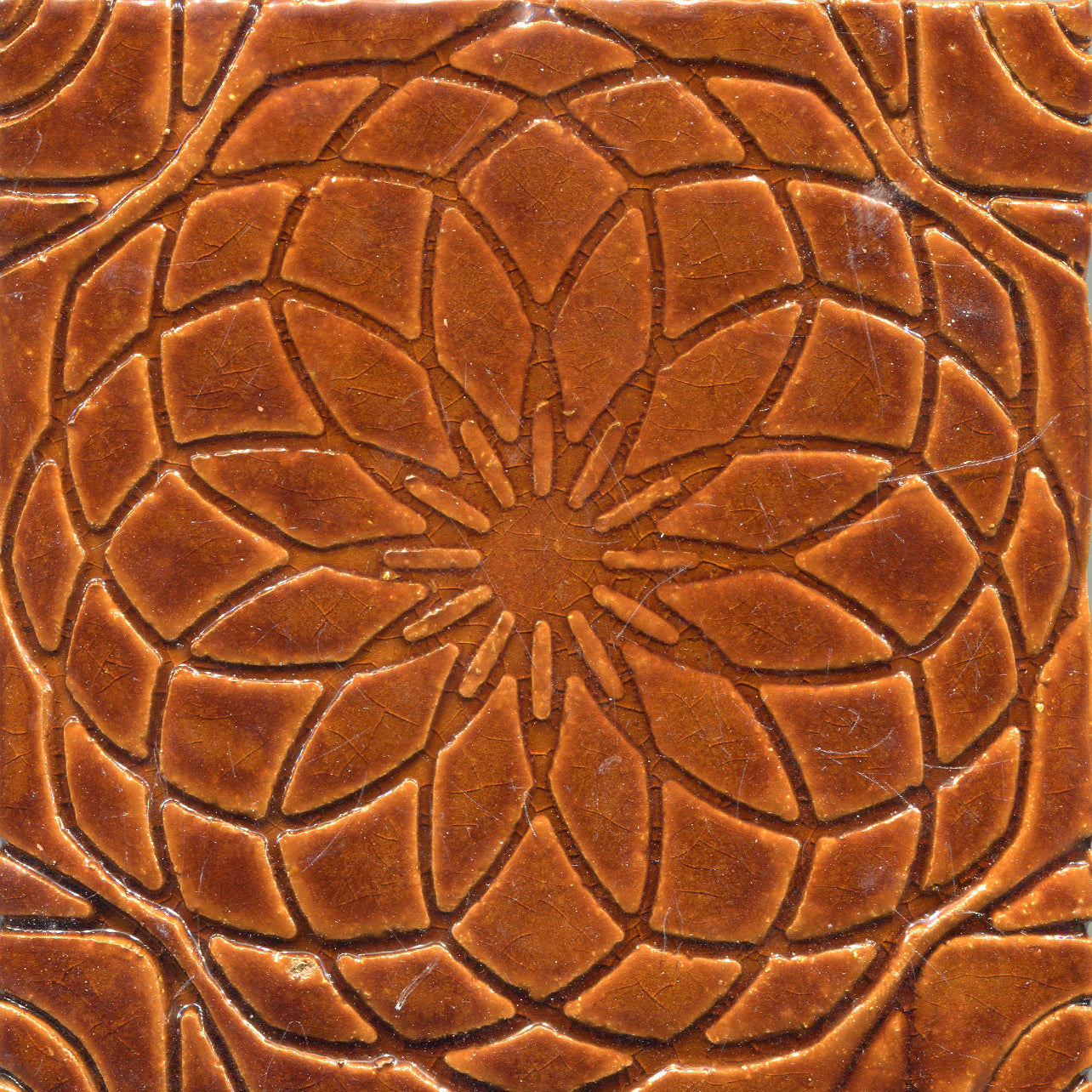 Brown gloss stamped tile with a geometric floral pattern.