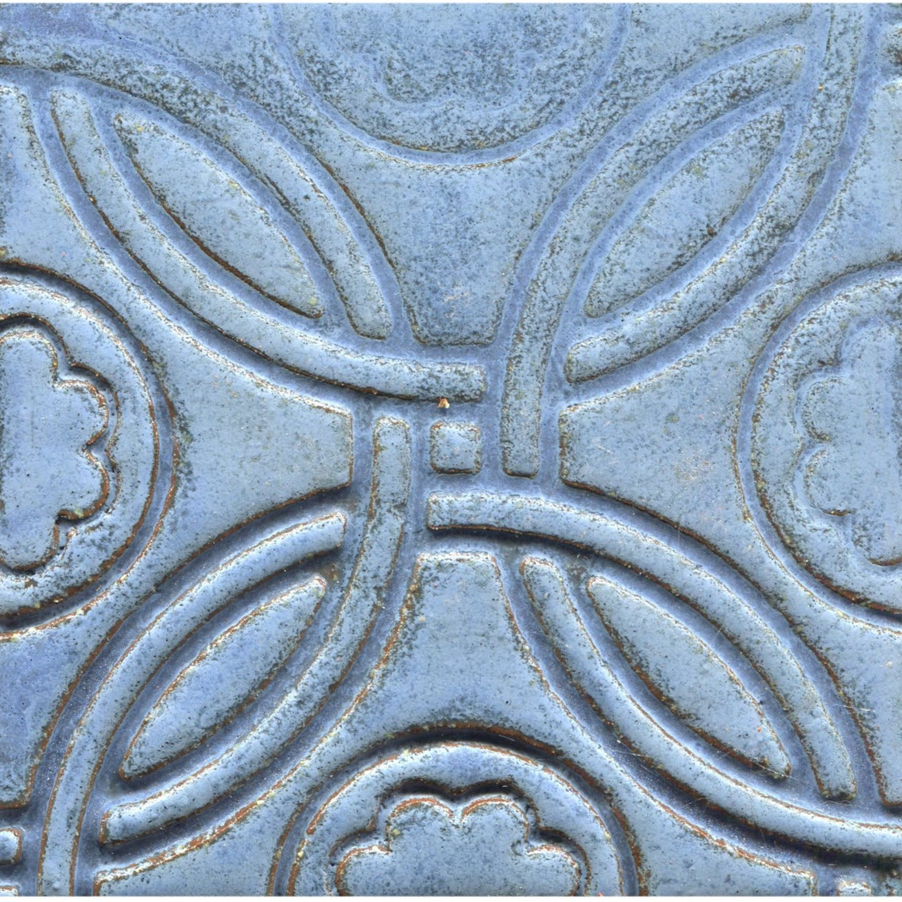 A Celtic inspired geometric pattern on stamped tiles in matte blue