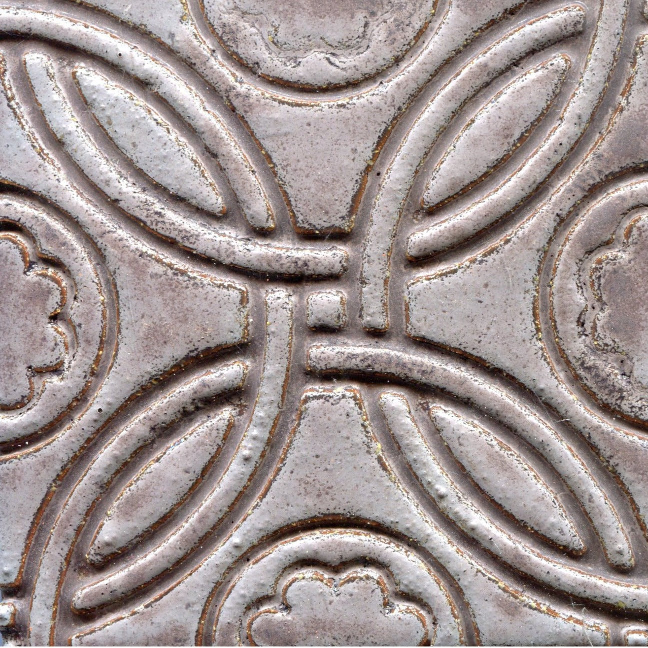 A Celtic inspired geometric pattern on stamped tiles in grey