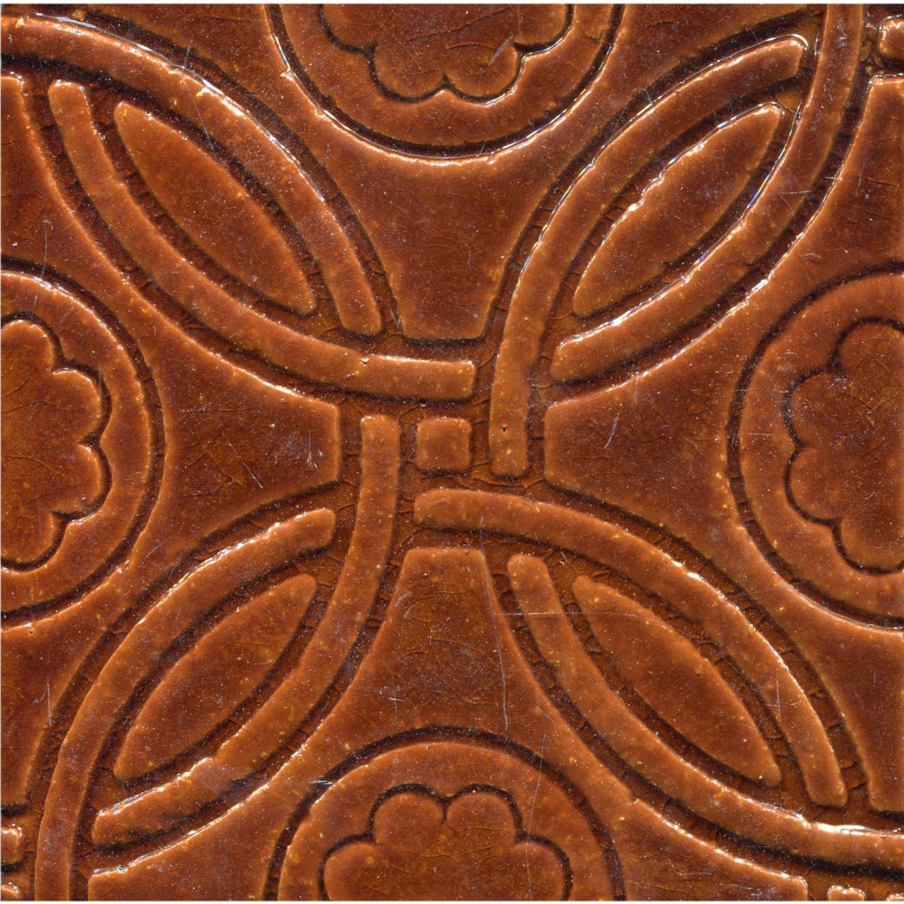 A Celtic inspired geometric pattern on stamped tiles in gloss brown