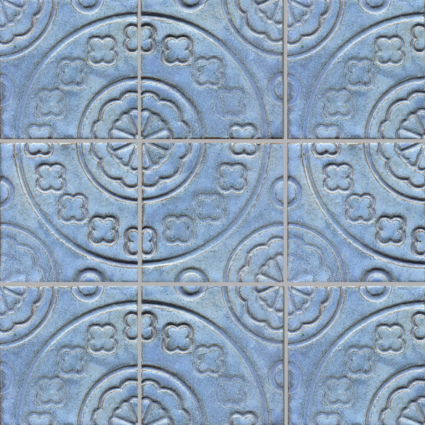 Clover-shaped stamped tiles in a blue color, arranged in a pattern.