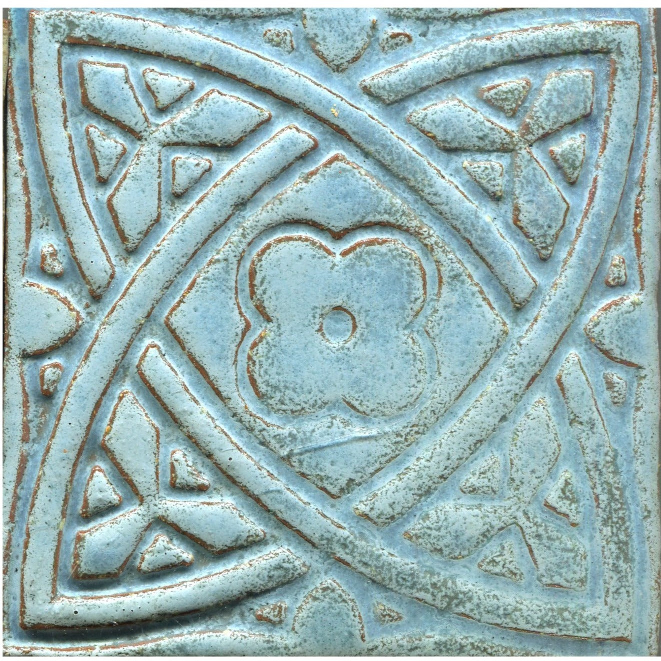 Matte blue stamped tiles with a Celtic geometric pattern.
