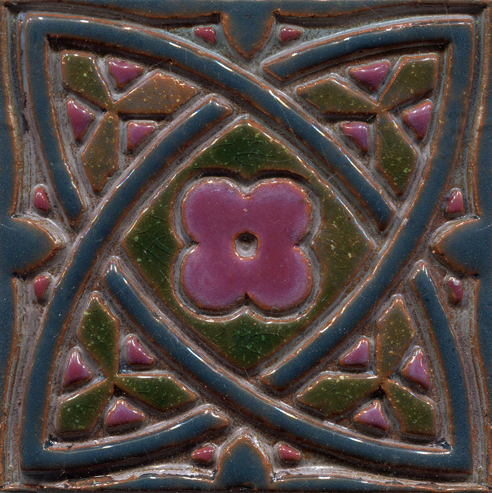 A collection of green stamped tiles with a Celtic geometric pattern.