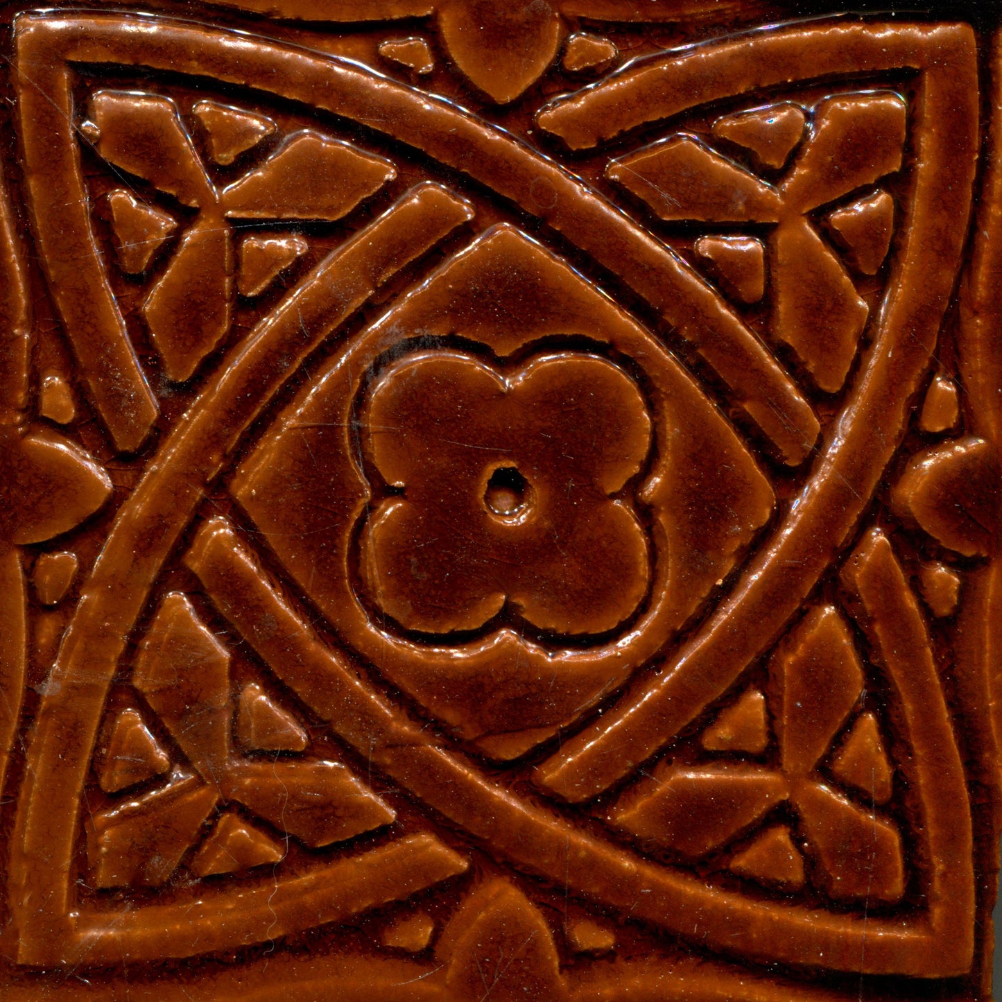 Gloss brown stamped tiles with a Celtic geometric pattern.