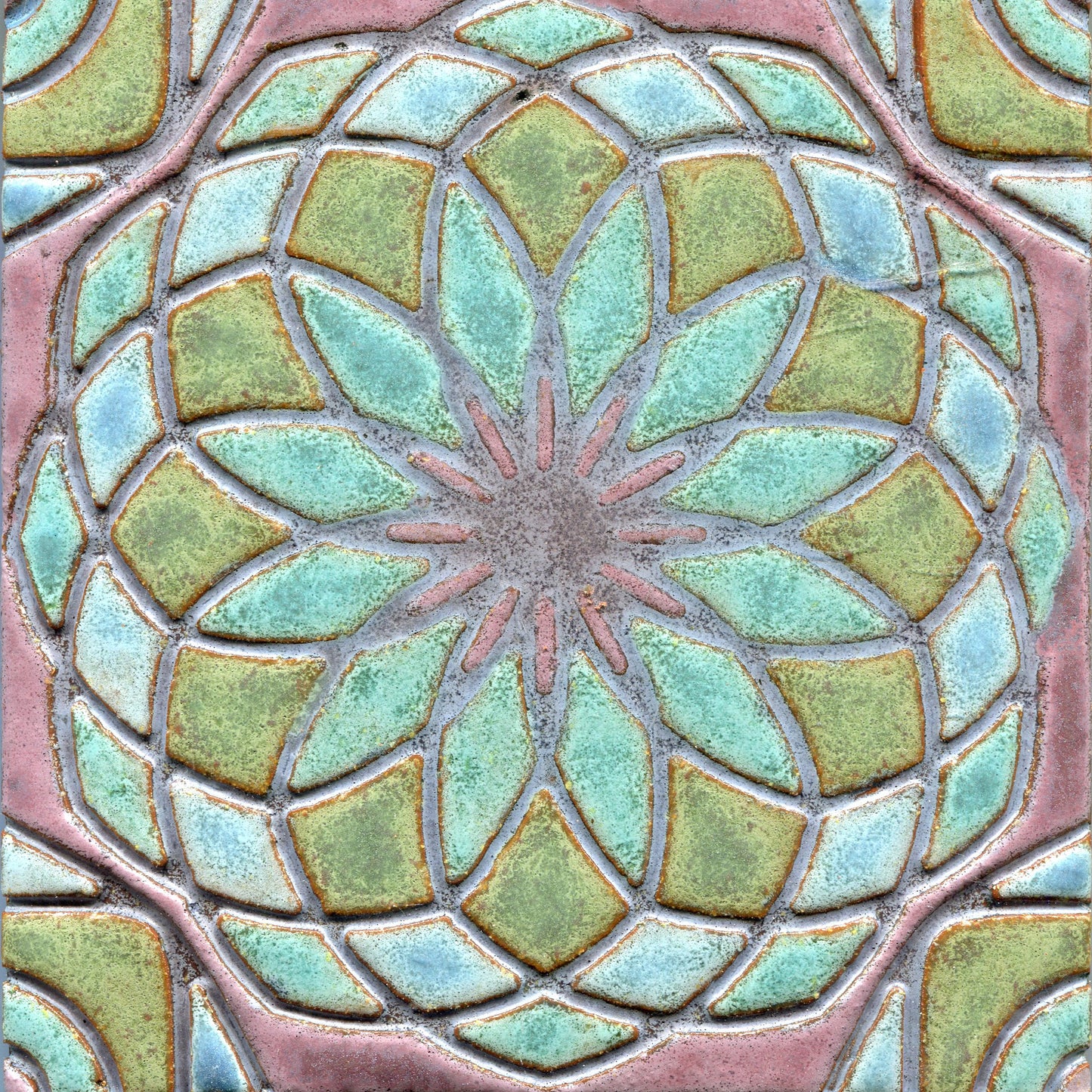 Pastel blues and greens stamped tile with a geometric floral pattern.