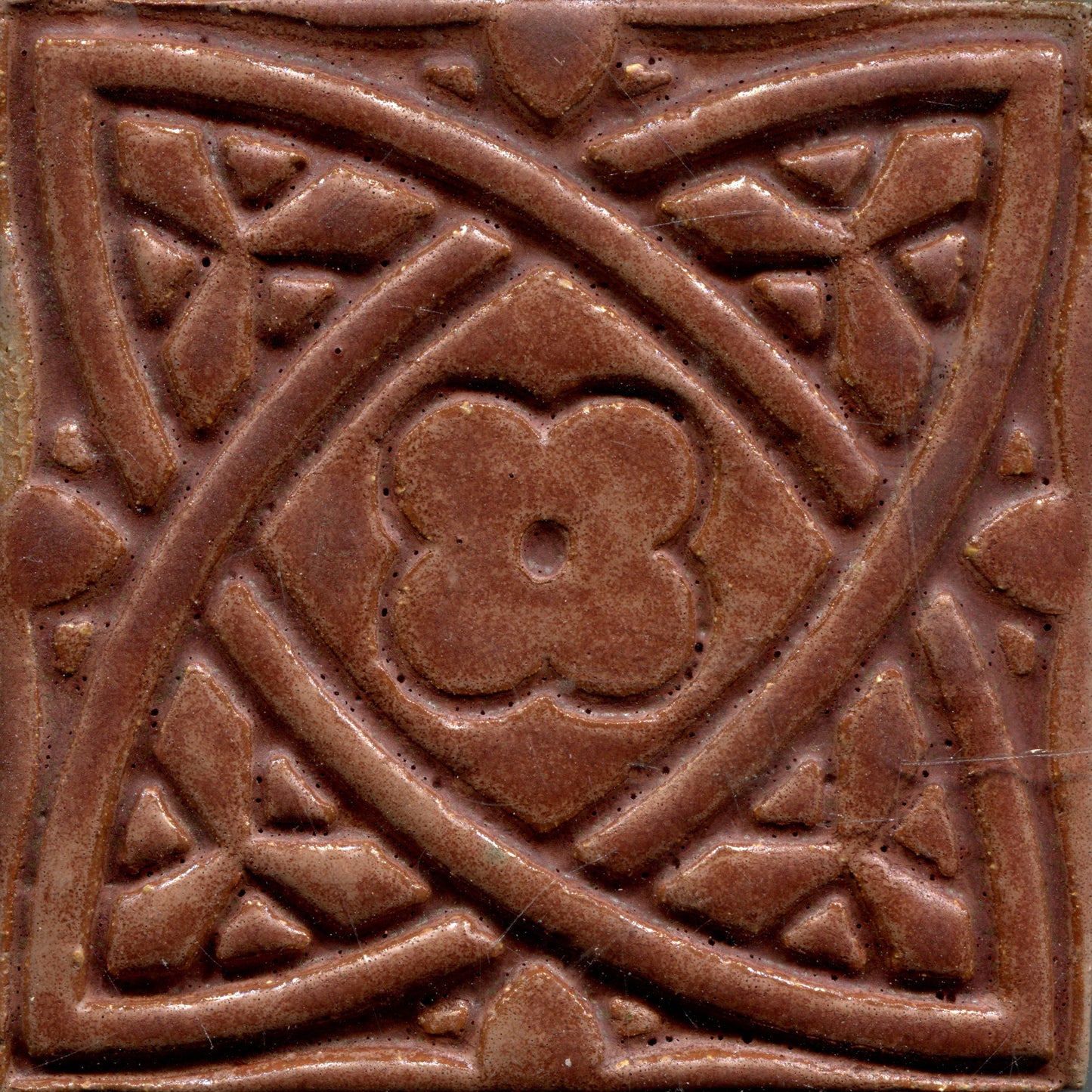 Matte brown stamped tiles with a Celtic geometric pattern.