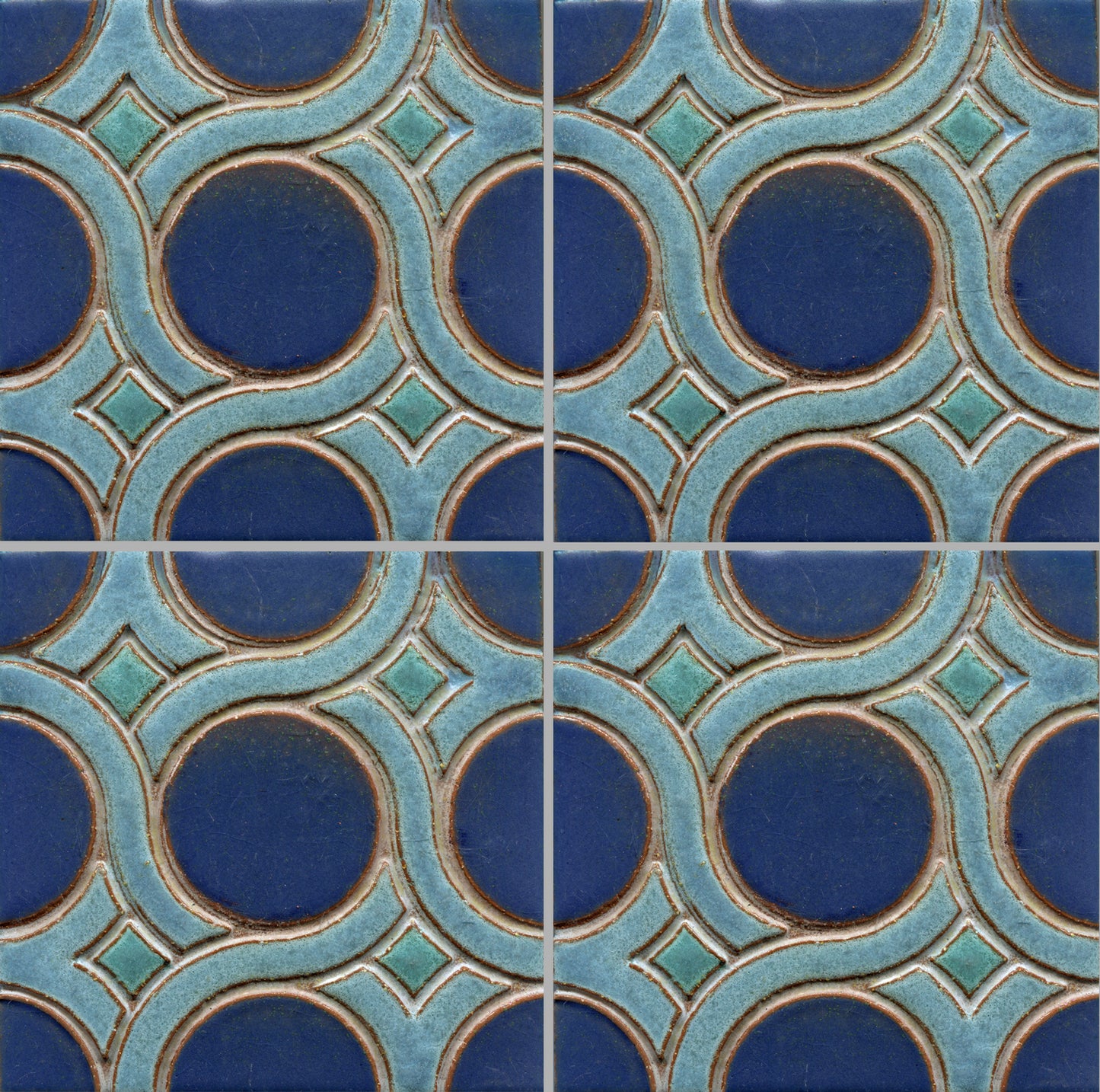 A pattern of woven knots on stamped tiles, with blue and green colors creating a geometric design.