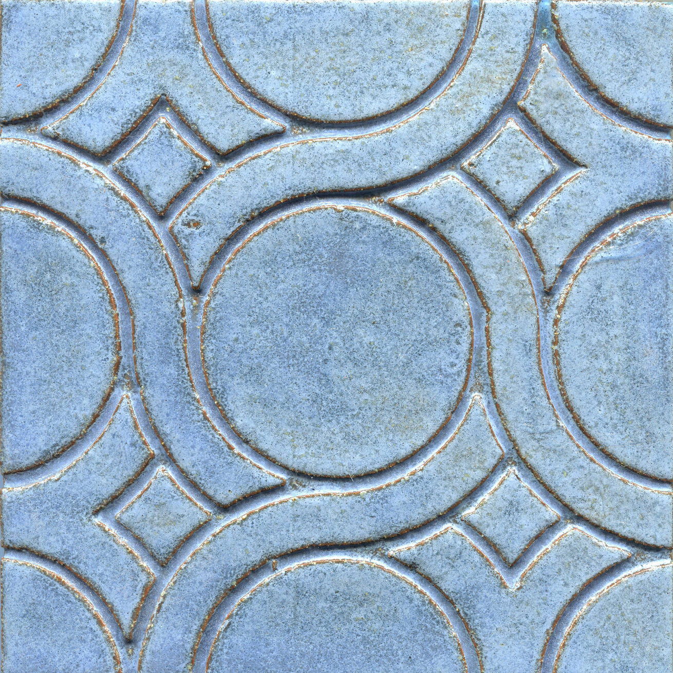 A pattern of woven knots on stamped tiles, with blue colors creating a geometric design.