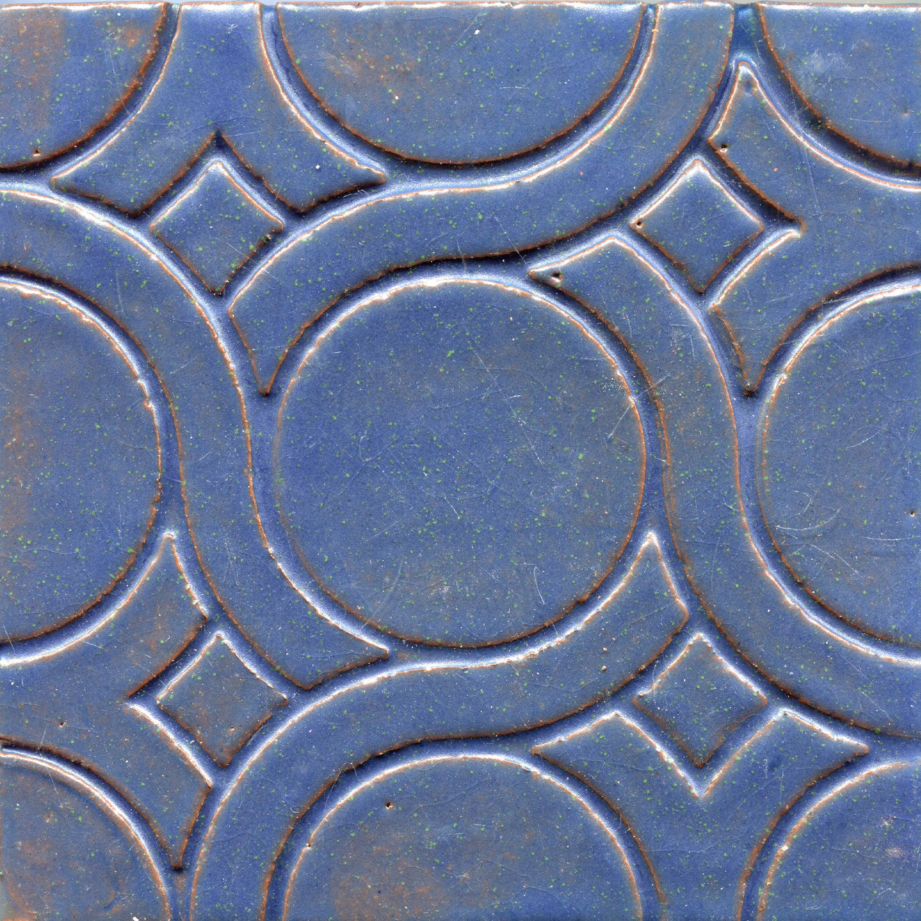 A pattern of woven knots on stamped tiles, with blue colors creating a geometric design.