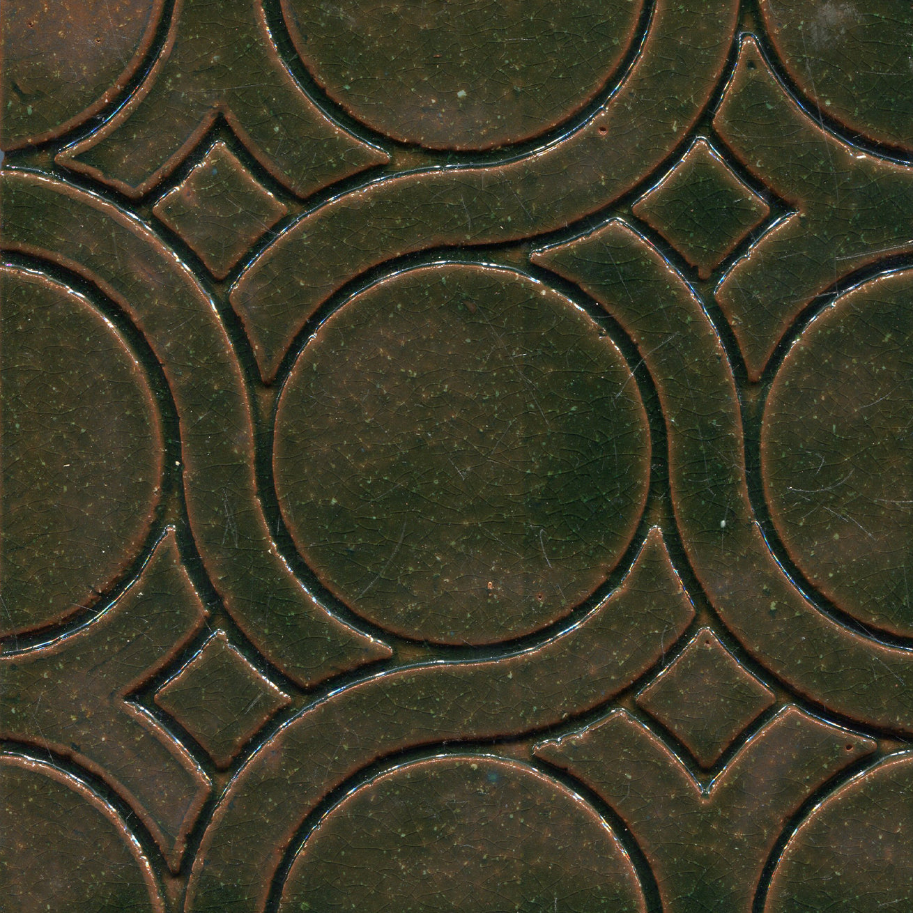 A pattern of woven knots on stamped tiles, with blue and green colors creating a geometric design.
