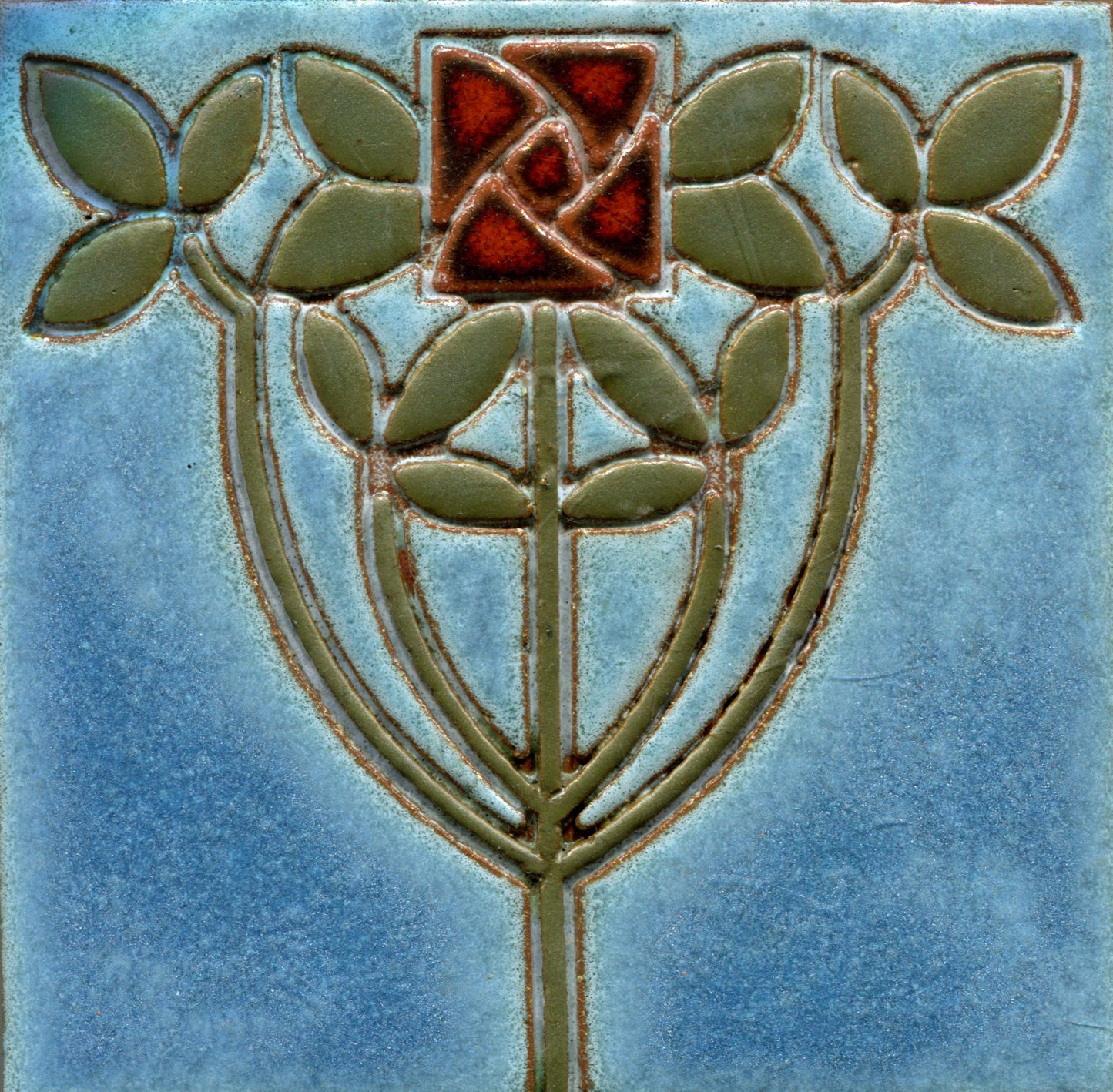 Decorative tile with a stylized flower design on a blue background