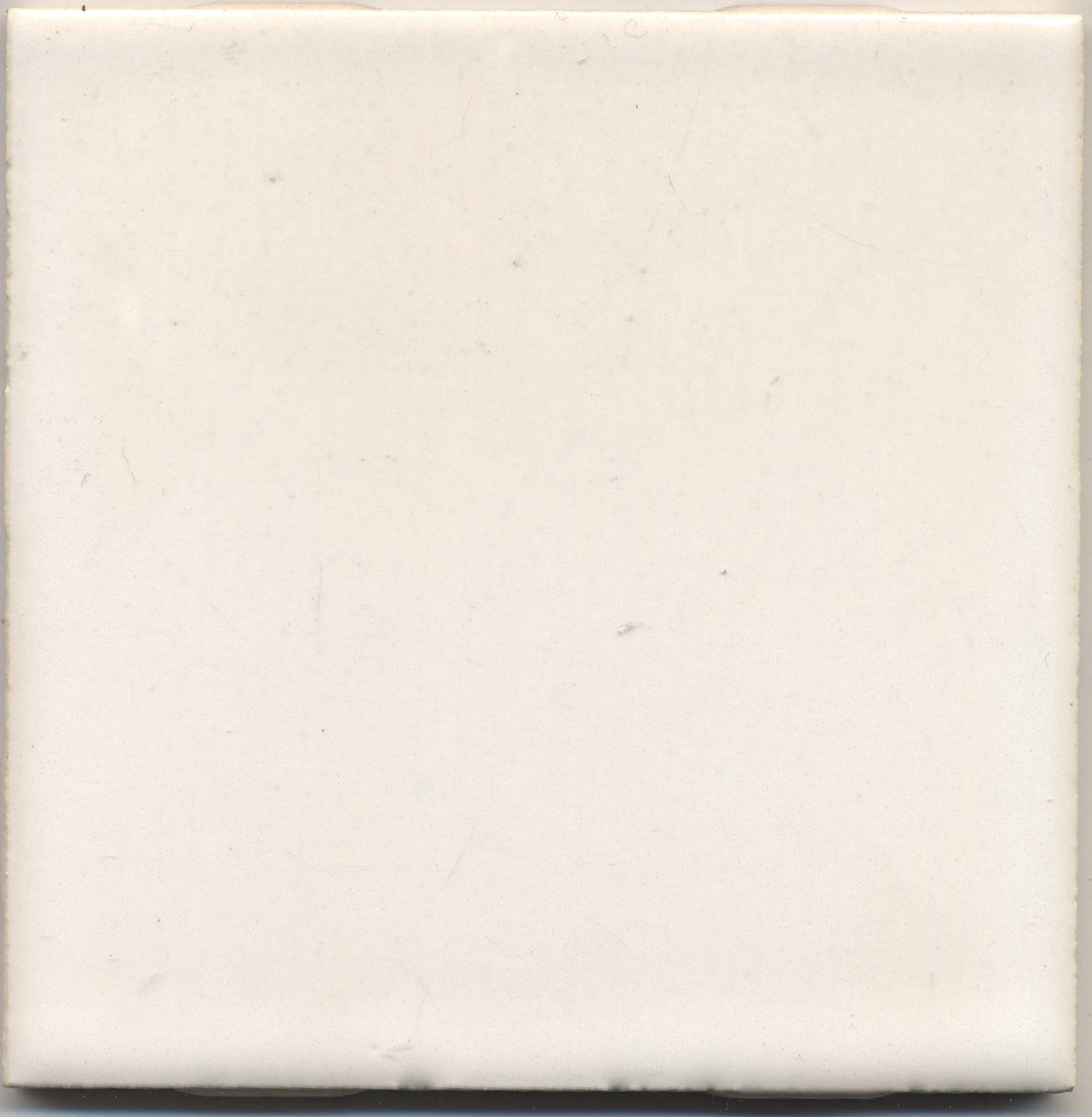 A single white ceramic subway tile with a opaque gloss finish.