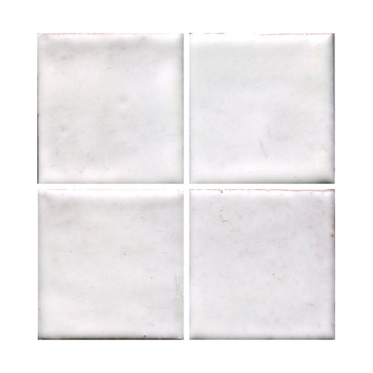 Four square tiles with a matte white finish and low variation in color, displaying occasional dots of blue or green.