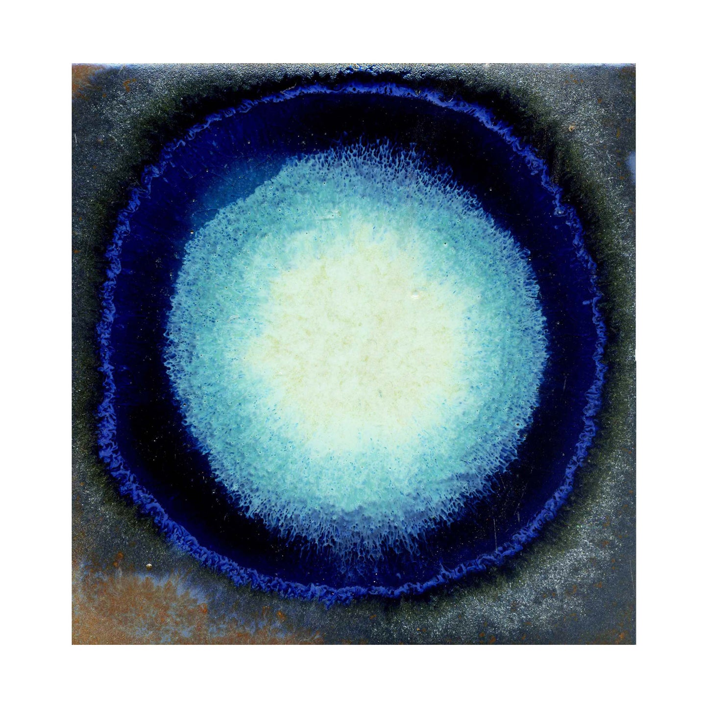 A close-up image of a surface with a light blue spot in the center, transitioning from a dark blue to a deep blue color around the edge.