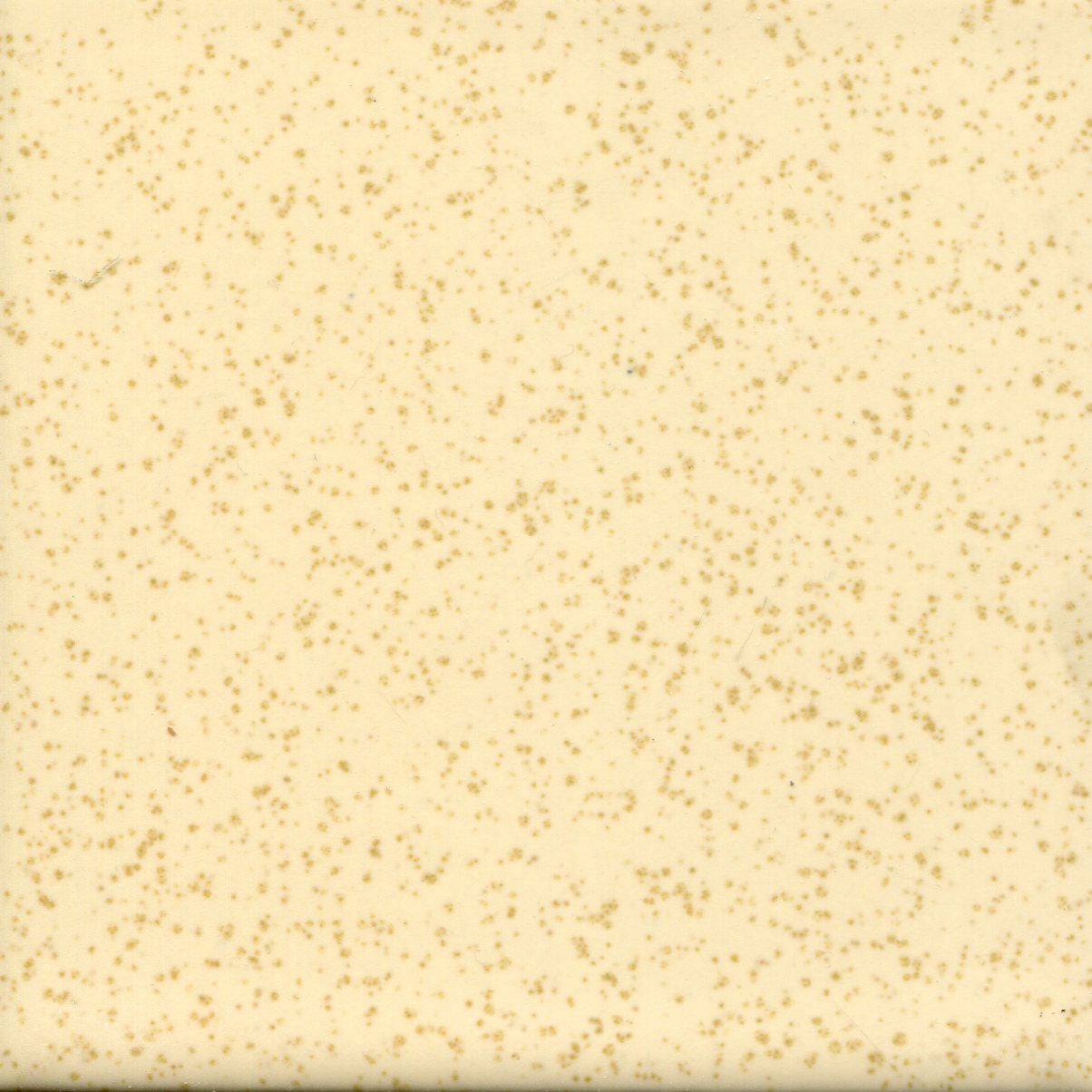 A spotted tile with a creamy yellow background and light brown flecks.