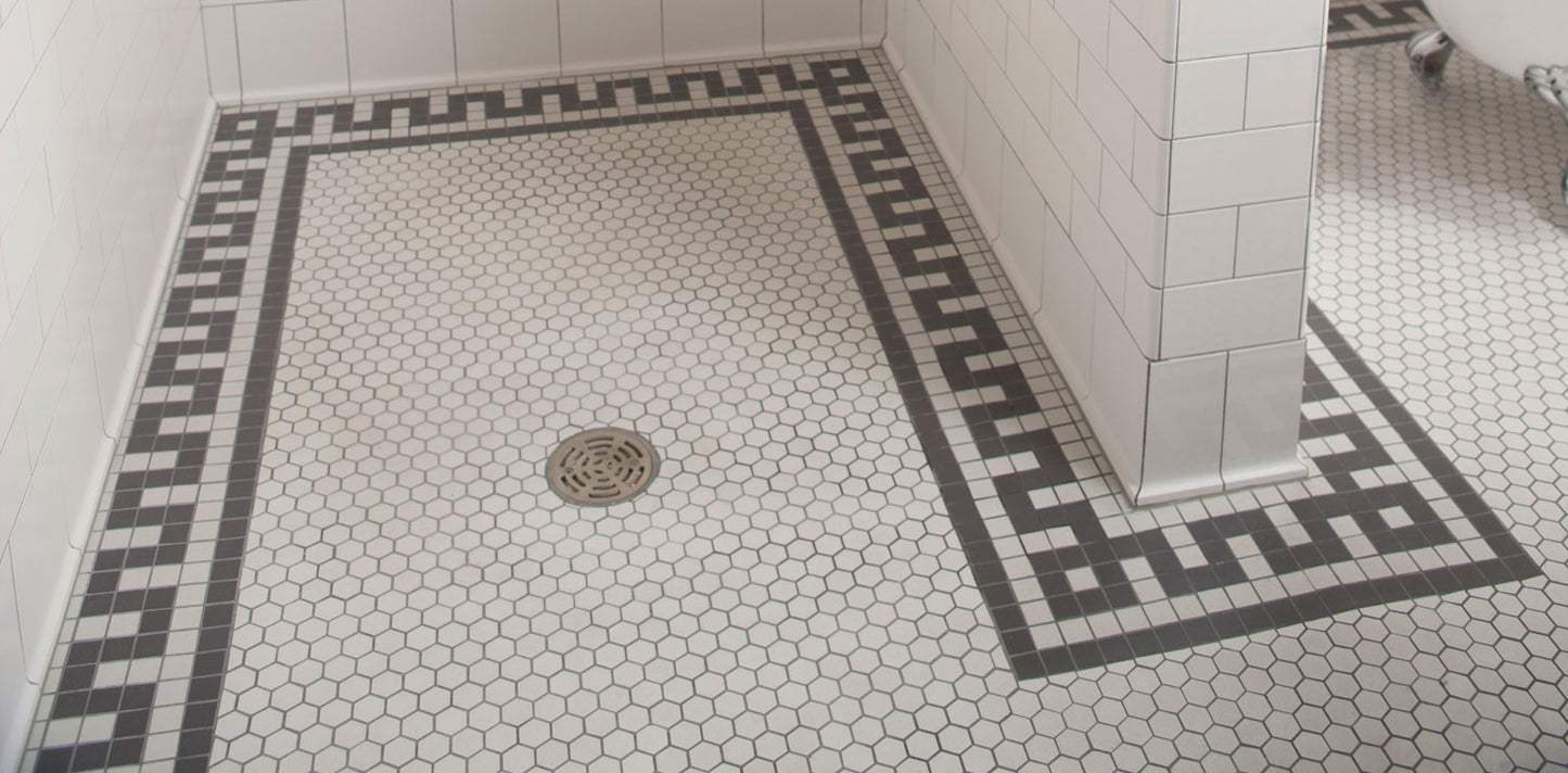 Shower floor with modified doric key border and white hex floor