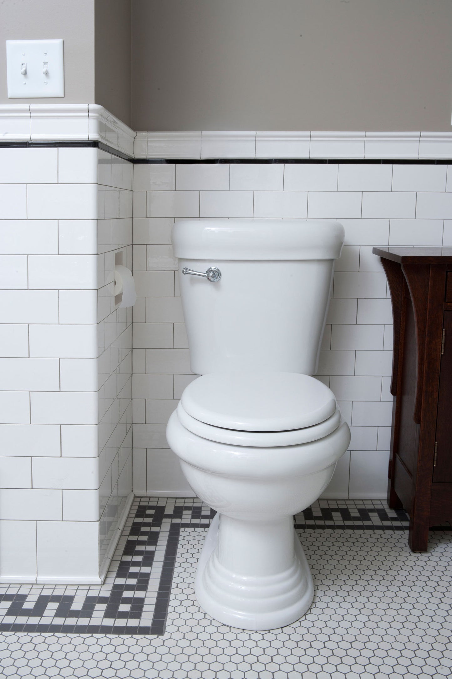 Flat Edge Subway tile wainscoting and modified doric key border and hexagon floor with toilet