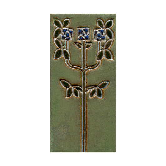 Decorative tile with floral design on a green background