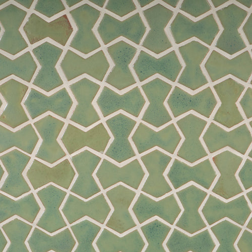 A close-up bowtie tiles of Pesto green  with a geometric pattern