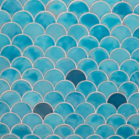 A close-up image of a light blue peacock patterned tile, showcasing its interlocking shape.