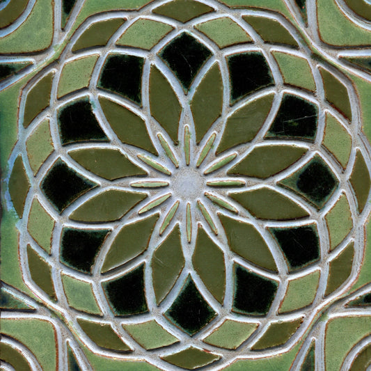 Green stamped tile with a geometric floral pattern.