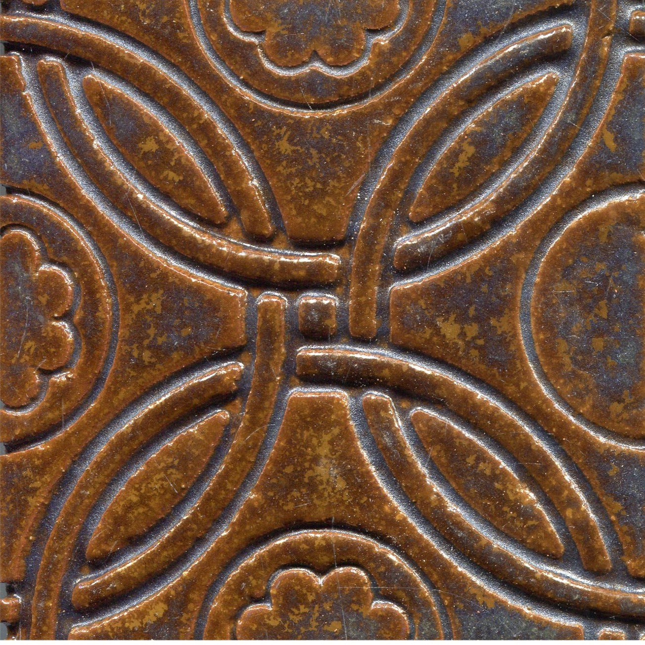 A Celtic inspired geometric pattern on stamped tiles in  copper blue