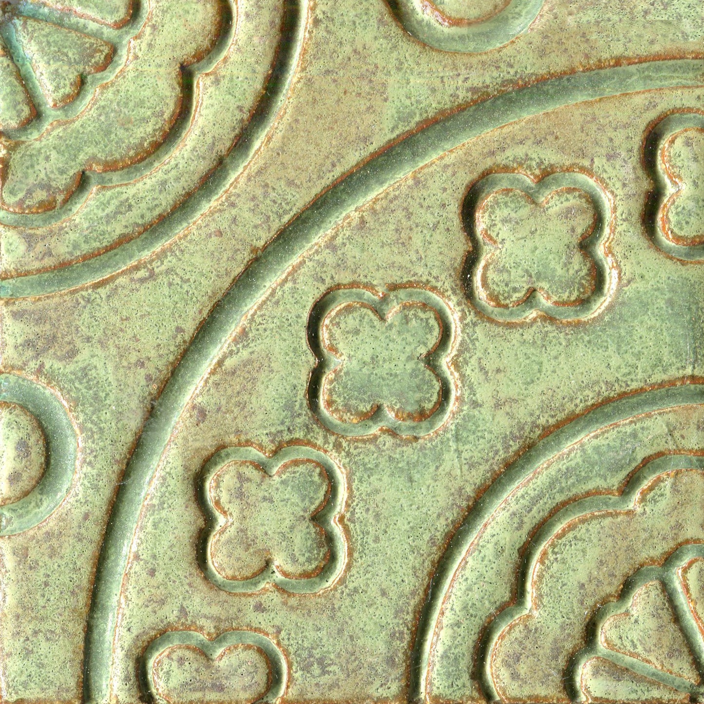 Matte green floral patterned tile, which is part of a set of connectable accent tiles.